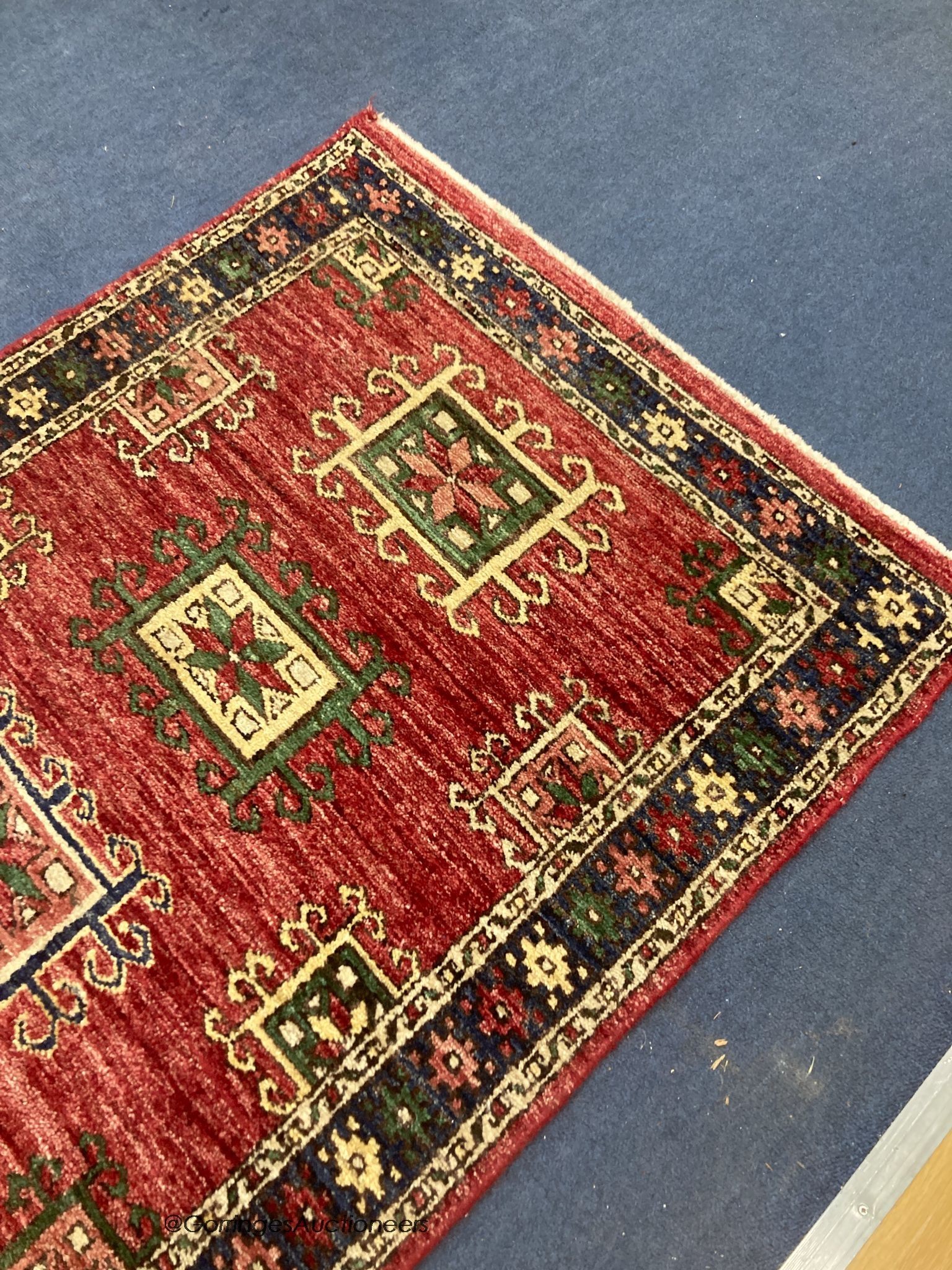 A Caucasian style red ground runner, 240 x 80cm